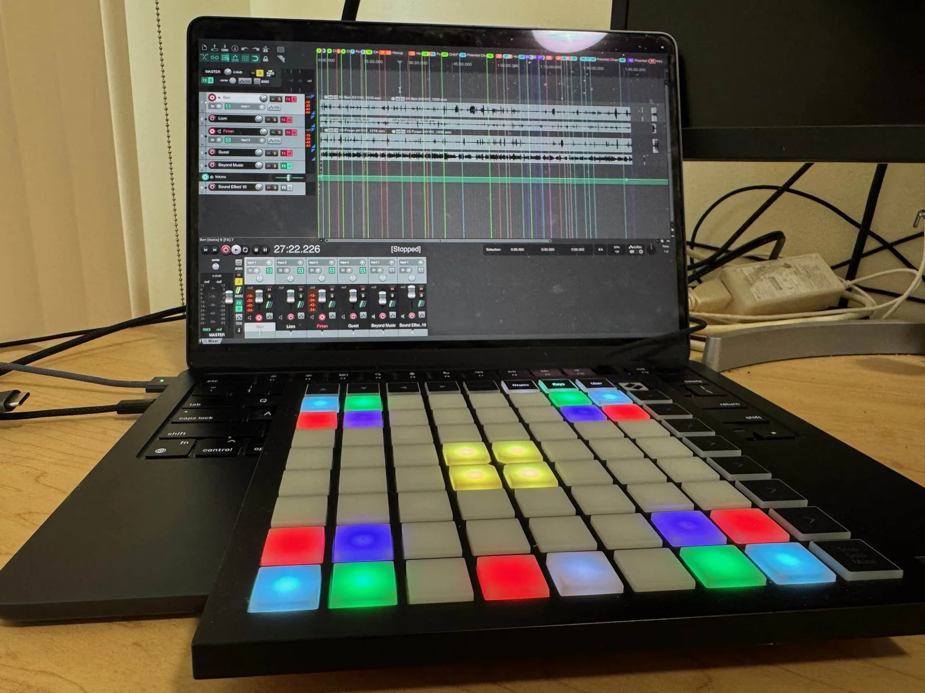 A laptop running REAPER beside a colorful Launchpad MIDI controller